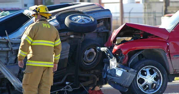 Fire fighter stands by aftermath of car crash